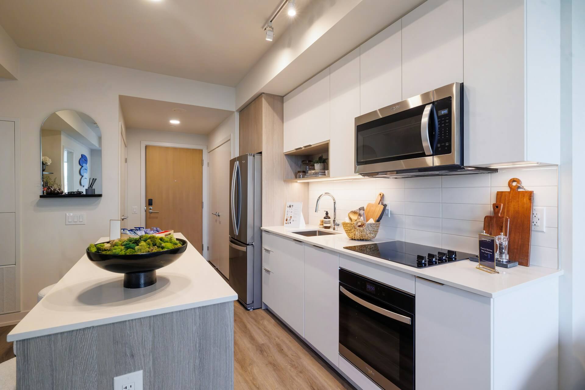 Vitt kök med krom-färgade vitvaror.