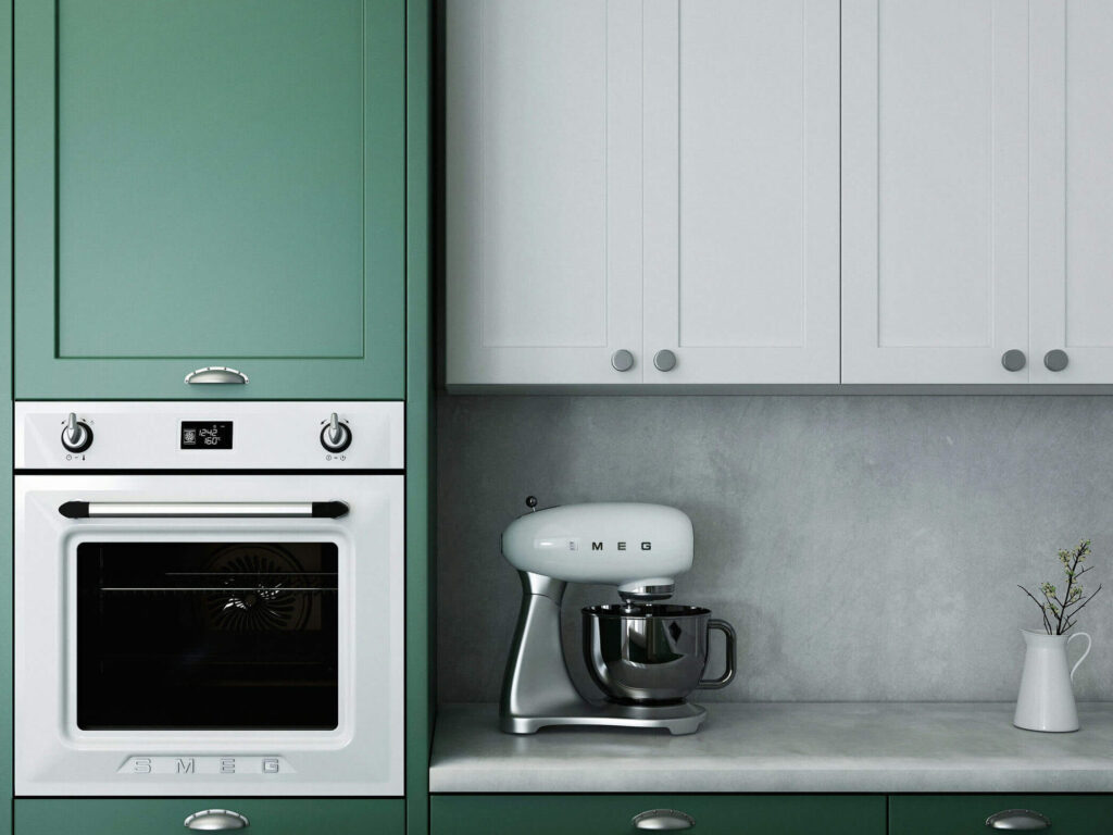 Närbild på kök med ugn i krom och smeg mixer på köksbänken.